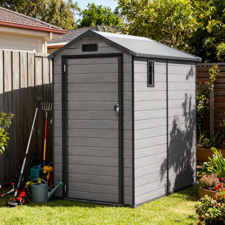 Patioslife YardVault 4x6ft resin garden storage shed with built-in floor, lockable door and side window beside backyard tools