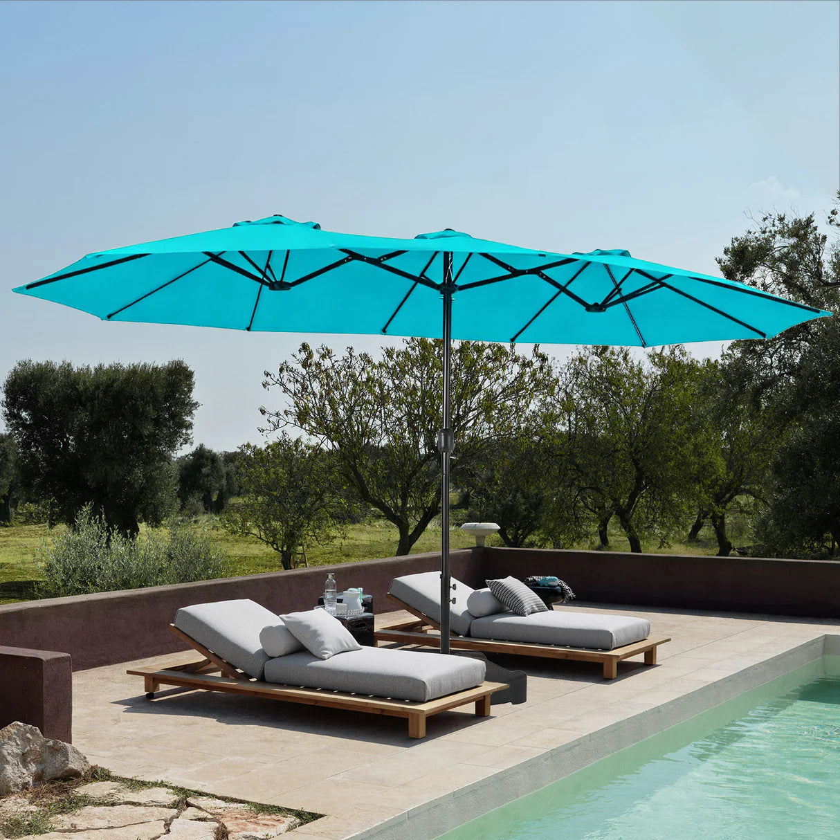 Patioslife Horizon 15 x 9 ft Turquoisedouble-sided patio umbrella shading two poolside loungers on a sunny terrace