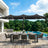 Patioslife 15 x 9 ft black double-sided patio umbrella with LED lights over poolside dining table and forest backdrop