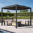 Patioslife Atlantic charcoal aluminum louvered pergola with closed adjustable roof over outdoor sofas and a coffee table beside a pool and green garden hedge