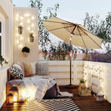Patioslife 8ft tan patio umbrella on a cozy balcony lounge with string lights, cushions and evening outdoor decor