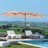 Patioslife Horizon 15 x 9 ft tan double-sided patio led light
umbrella shading a modern outdoor lounge area near the sea